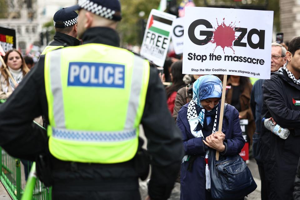 Police officers monitor protesters in Parliament Square during the 'March For Palestine' in London on October 28, 2023, to call for a ceasefire in the conflict between Israel and Hamas. Thousands of civilians, both Palestinians and Israelis, have died since October 7, 2023, after Palestinian Hamas militants based in the Gaza Strip entered southern Israel in an unprecedented attack triggering a war declared by Israel on Hamas with retaliatory bombings on Gaza. (Photo by HENRY NICHOLLS / AFP) (Photo by HENRY NICHOLLS/AFP via Getty Images)