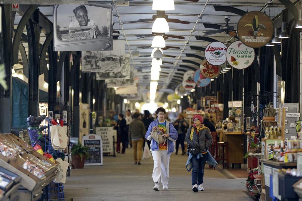 This Jan. 15, 2013 photo shows people walking through the French Market in New Orleans. The centuries-old commercial hub stretches for several city blocks along the bank of the Mississippi River in the French Quarter and includes Cafe du Monde, home of the deep-fried, sugar-coated beignet, a popular New Orleans pastry. (AP Photo/Gerald Herbert)