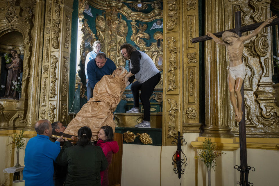 Members of the "Vera Cruz" Catholic brotherhood place back the "Virgen de los dolores" after a Holy Week procession in the southern town of Quesada, Spain, Saturday, March 30, 2024. (AP Photo/Bernat Armangue)