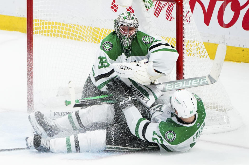 Dallas Stars' Radek Faksa (12) slides into Stars' goaltender Anton Khudobin (35) during third-period NHL hockey game action against the Ottawa Senators in Ottawa, Ontario, Sunday, Oct. 17, 2021. (Sean Kilpatrick/The Canadian Press via AP)