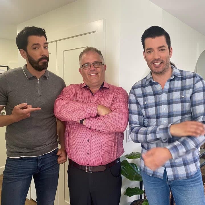 Alan Hrehirchuk stands between Drew and Jonathan Scott from the popular Property Brothers HGTV show. Hrehirchuk and his company, Envision Custom Renovations, did work on at least two episodes of the show. Hrehirchuk pleaded guilty to fraud on Monday for a project unrelated to the show.  (Facebook/Envision Custom Renovations Inc. - image credit)