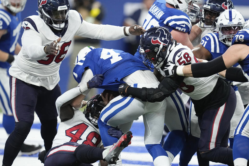 Indianapolis Colts quarterback Sam Ehlinger (4) is sacked by Houston Texans linebacker Christian Harris (48) and linebacker Christian Kirksey (58) during the first half of an NFL football game between the Houston Texans and Indianapolis Colts, Sunday, Jan. 8, 2023, in Indianapolis. (AP Photo/Darron Cummings)