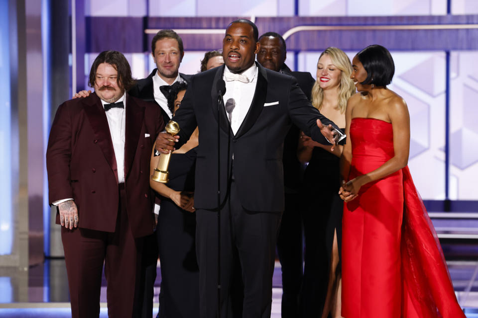 En esta imagen proporcionada por CBS, Lionel Boyce, centro, con el elenco de "The Bear" al recibir el premio a la mejor serie musical o de comedia en la 81a edición de los Globos de Oro el domingo 7 de enero de 2024, en el Hotel Beverly Hilton en Beverly Hills, California. (Sonja Flemming/CBS via AP)