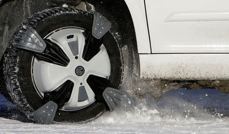 Automatic snow chains are mounted on the wheel of a car driving through the ski resort Ovcarna near the village of Karlova Studanka, Czech Republic January 19, 2017. REUTERS/David W Cerny