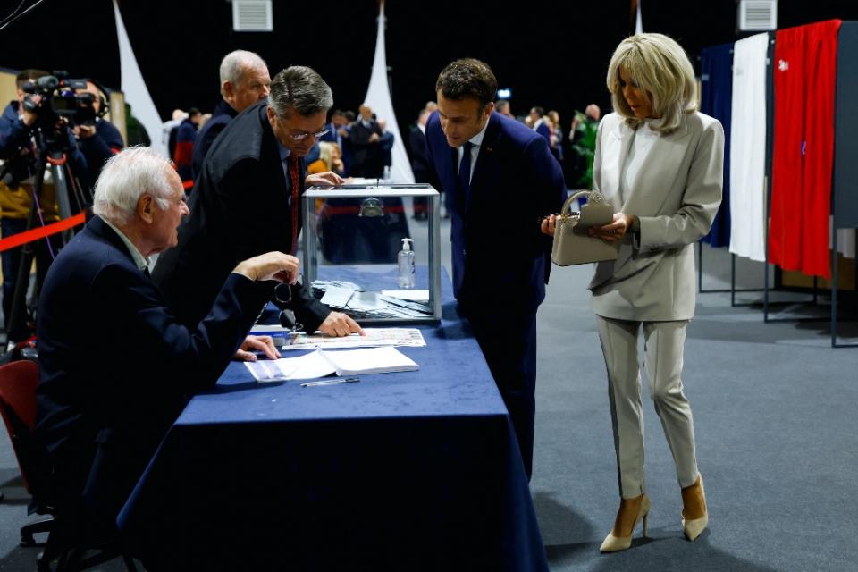 Brigitte Macron and Emmanuel Macron vote at a polling station in Le Touquet, France on April 24, 2022. - Credit: Gonzalo Fuentes; Pool via AP