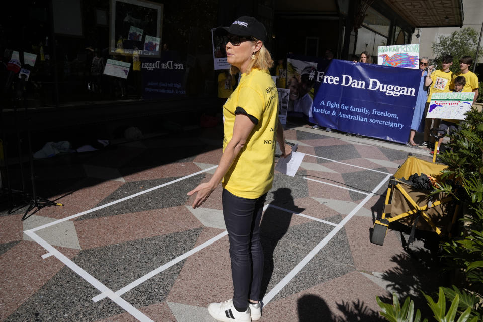 Saffron Duggan stands on a representation of the size of her husband's cell as she speaks outside Downing Central Court in Sydney, Monday, Oct. 23, 2023, as family and supporters of Dan Duggan demonstrate. A Sydney court on Monday postponed an extradition hearing for Dan Duggan, a former U.S. military pilot accused of illegally training Chinese aviators, until May as his lawyers attempt to further build their case. (AP Photo/Rick Rycroft)