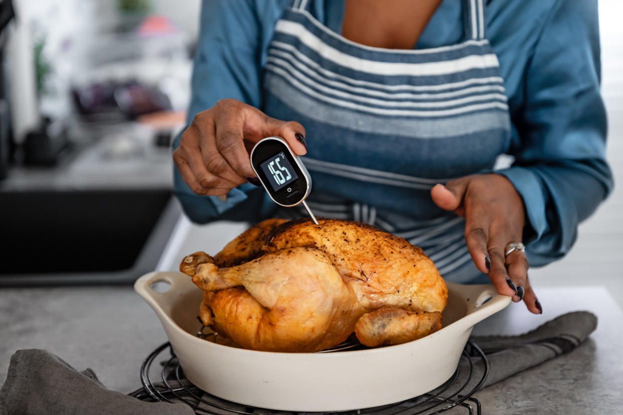 Hygienic food handling procedures, woman using meet thermometer on chicken