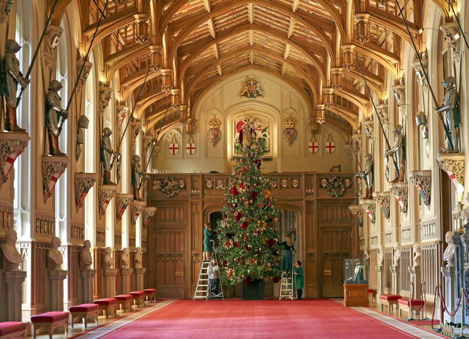 A Royal Collection Trust member of staff puts the finishing touches to a 20ft Nordmann fir tree, sourced from the Windsor Great Park, in St George's Hall at Windsor Castle, Berkshire. (Photo by Steve Parsons/PA Images via Getty Images)