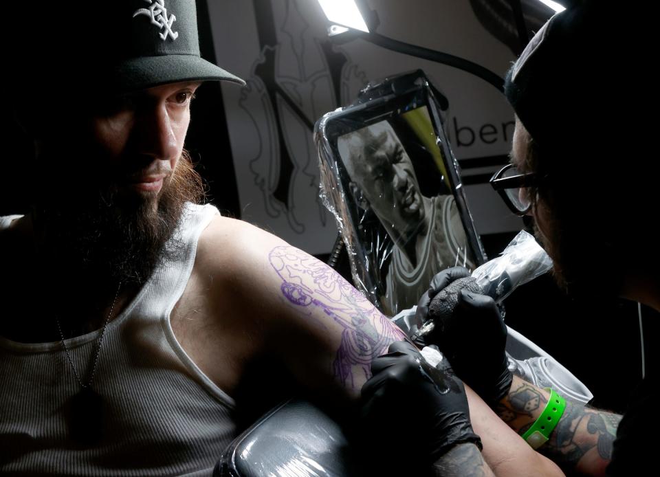 From left, Bill McGrath, 37, of Chicago waits patiently as Ben Petee of North Main Tattoo Studio in Plymouth works on his Michael Jordan tattoo during the 28th annual Motor City Tattoo Expo at the Renaissance Center in Detroit on Saturday, March 2, 2024. Close to 300 of the best tattoo artists from around the world and some from Michigan and metro Detroit were at the convention.