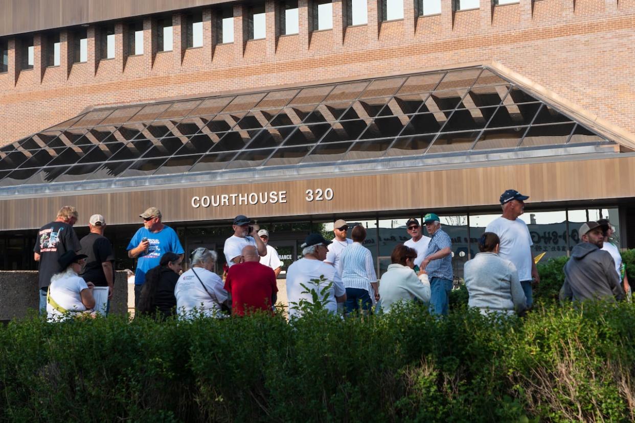 People gathered on June 12, 2023, to show support outside the Lethbridge Courthouse on the first day of pretrial for four men charged with conspiring to murder RCMP officers during the Coutts blockade. On Tuesday, Jerry Morin pleaded guilty to conspiracy to traffic firearms, and Christopher Lysak pleaded guilty to possession of a weapon in an unauthorized place. (Ose Irete/CBC - image credit)