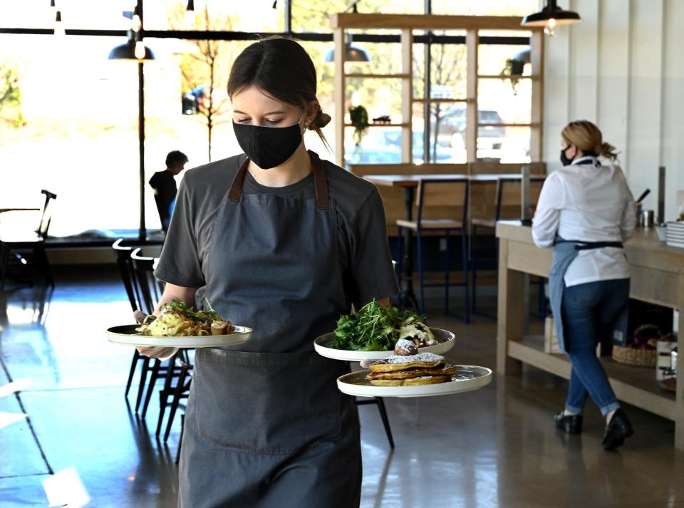 Food runner Courtney Brown carries dishes to a table at the Farmer's Daughter, a new breakfast, brunch and lunch eatery in Sudbury's Meadow Walk development, March 19, 2021.  