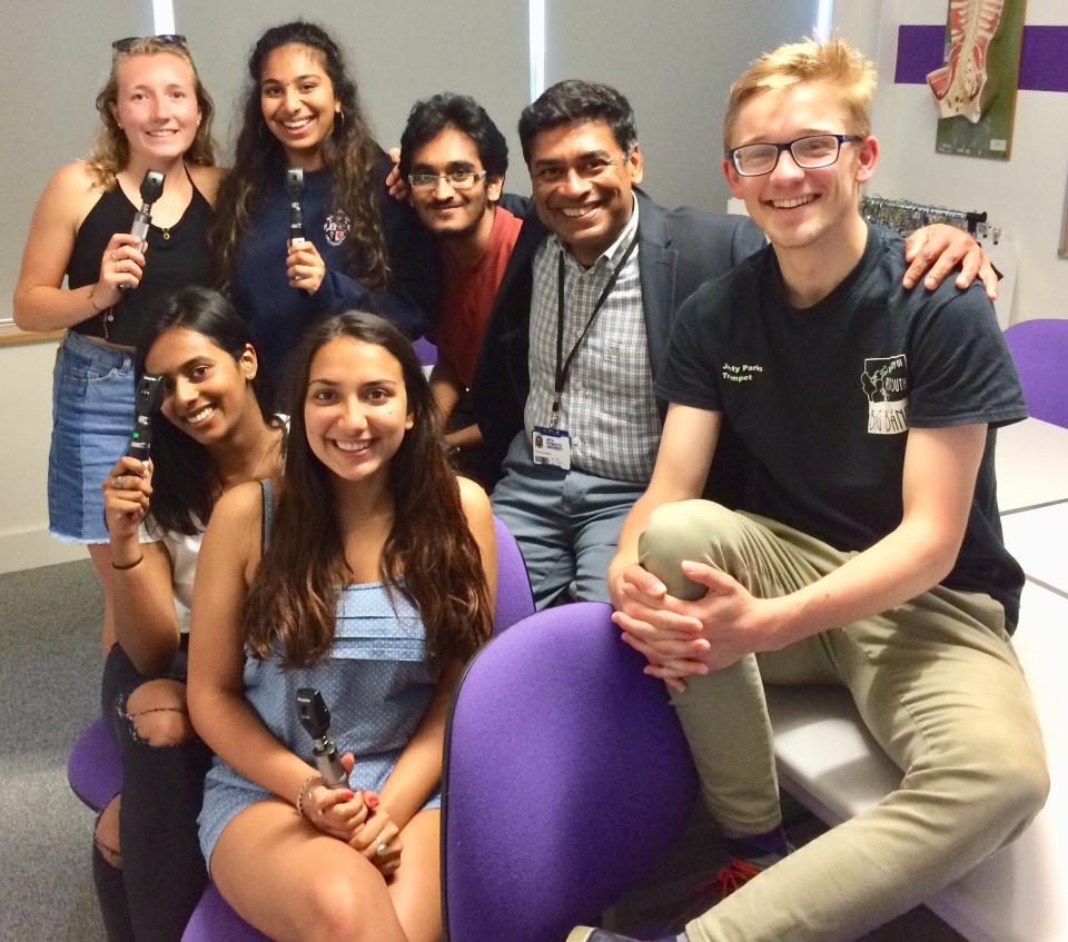 In this image taken in June 2018, Dr. Poorna Gunasekera, second right, poses with a group of medical students from Plymouth University who had just completed training in ophthalmoscopy. At his darkest moment in his struggle with the coronavirus, Dr. Poorna Gunasekera glimpsed the first rays of light when three of his former students came to help. Having endured a severe deterioration in his COVID-19 symptoms after around 12 days of contracting the virus, Gunasekera was rushed to Derriford Hospital in Plymouth, in the early hours of March 30. "It was wonderful that during that time, two of my former students, who are doctors, and another who was a nurse, actually came and they identified themselves," he told The Associated Press over several interviews following his release from hospital on April 9. (Poorna Gunasekera via AP)