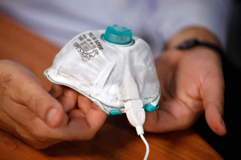 An Israeli researcher, part of a team which say they have invented a reusable face mask that can disinfect itself and kill the coronavirus disease (COVID-19), takes part in a demonstration for Reuters in Haifa, northern Israel