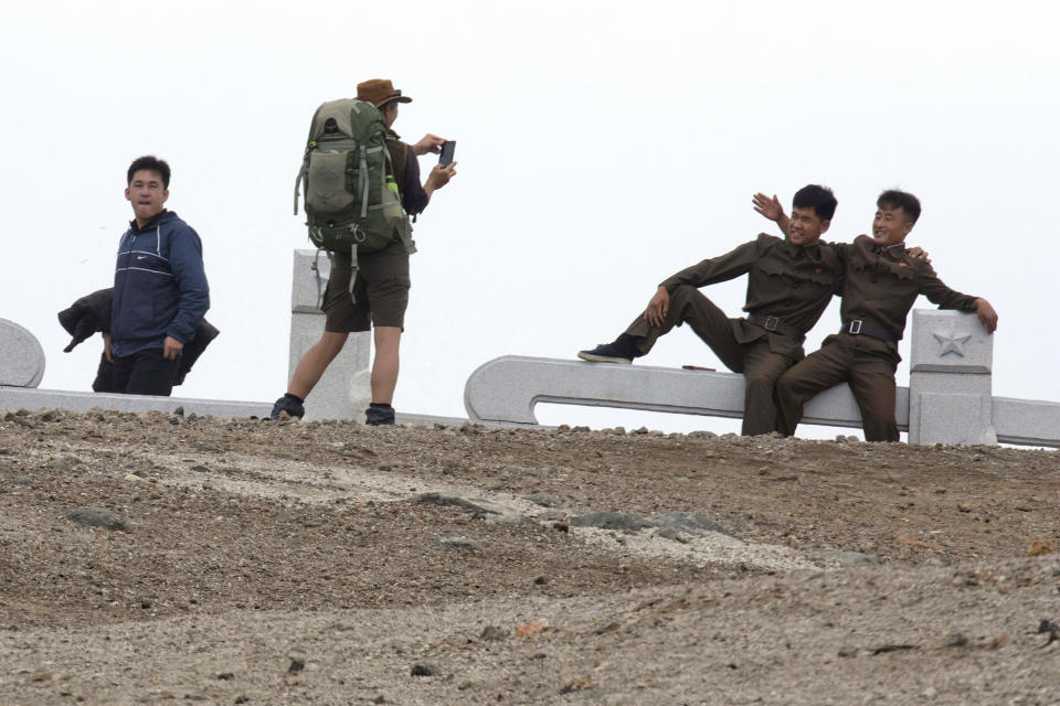 In this Saturday, Aug. 18, 2018, photo, Paula of Australia takes a photo for North Koreans during a hike arranged by Roger Shepherd of Hike Korea on Mount Paektu in North Korea. Hoping to open up a side of North Korea rarely seen by outsiders, Shepherd, a New Zealander who has extensive experience climbing the mountains of North and South Korea is leading the first group of foreign tourists allowed to trek off road and camp out under the stars on Mount Paektu, a huge volcano that straddles the border that separates China and North Korea. (AP Photo/Ng Han Guan)