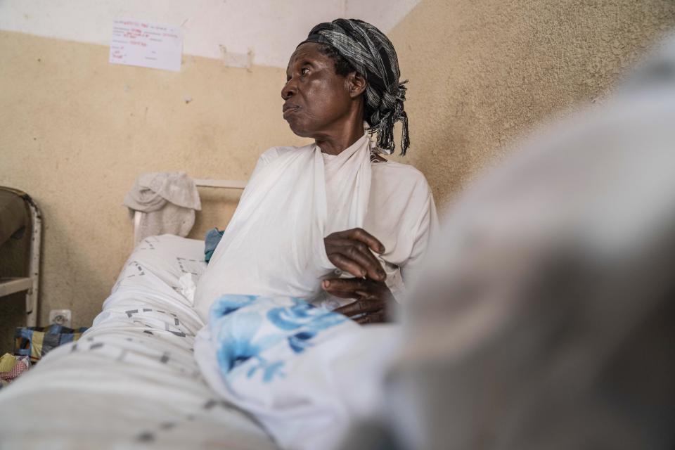 An elderly woman who was wounded in ongoing fighting between M-23 rebel forces and Congolese forces in the Sake region West of Goma, eastern Congo, sits on her hospital bed in Goma, Tuesday, Feb. 13, 2024. In recent days, main roads around Goma and Sake, routes that are crucial for the movement of civilians, goods, and humanitarian aid, have become impassable due to intensified fighting, further restricting access to essential services and supplies said humanitarian aid organisation, Mercy Corps. (AP Photo/Moses Sawasawa)