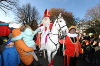 Saint Nicholas is escorted by his assistants called "Zwarte Piet" (Black Pete) during a traditional parade in Amsterdam, Netherlands, November 18, 2018. REUTERS/Eva Plevier