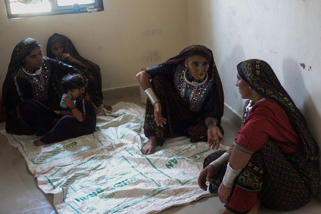 Women huddle around in a temporary shelter set at a health centre in Gujarat’s Jakhau village in Kutch district (AFP via Getty Images)