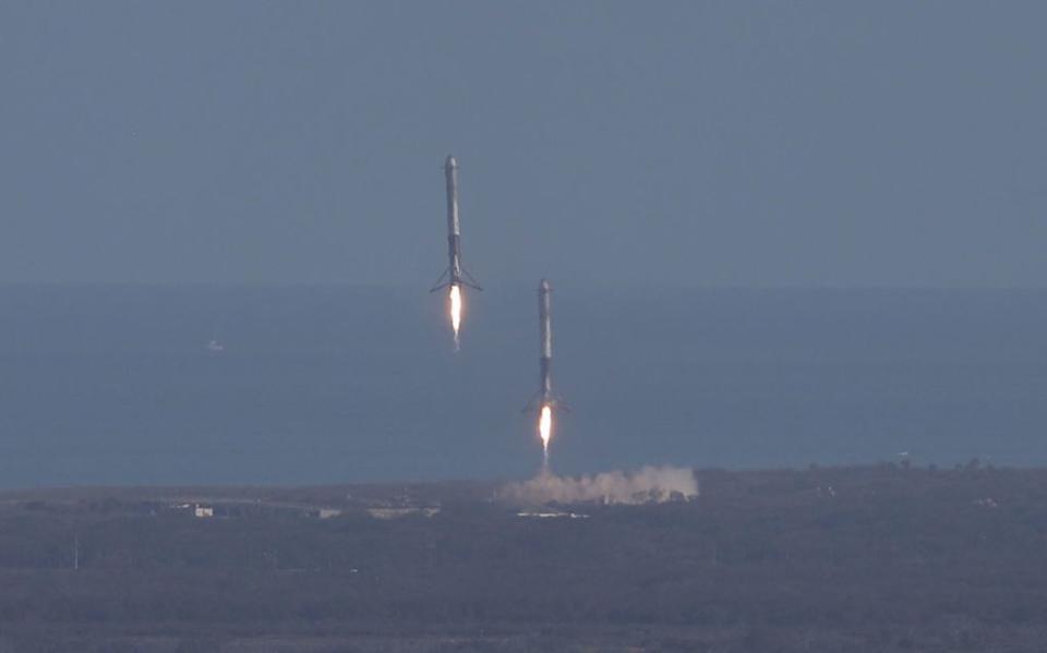 <p>Two of the boosters liftoff at Cape Canaveral Air Force Station after the launch of SpaceX Falcon Heavy rocket from launch pad 39A at Kennedy Space Center on February 6, 2018 in Cape Canaveral, Florida. (Photo by Joe Raedle/Getty Images)</p>