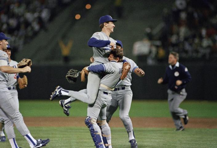 Dodgers pitcher Orel Hershiser is lifted in the air by catcher Rick Dempsey.