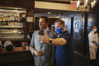 Steve Tukavkin, right, takes a selfie with a wax statue of actor John Hamm at Peter Luger Steakhouse on Friday, Feb, 26, 2021, in Brooklyn, NY. The statue, on loan from Madame Tussauds, will help fill out the restaurant during COVID-19 occupancy restrictions. (AP Photo/Kevin Hagen)