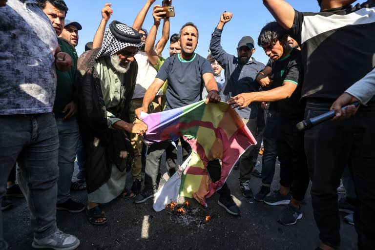 (FILES) Supporters of Shiite Muslim leader Moqtada Sadr burn a rainbow flag outside the Swedish embassy in Baghdad, after they breached the building over the burning of the Koran by an Iraqi living in Sweden (Ahmad AL-RUBAYE)