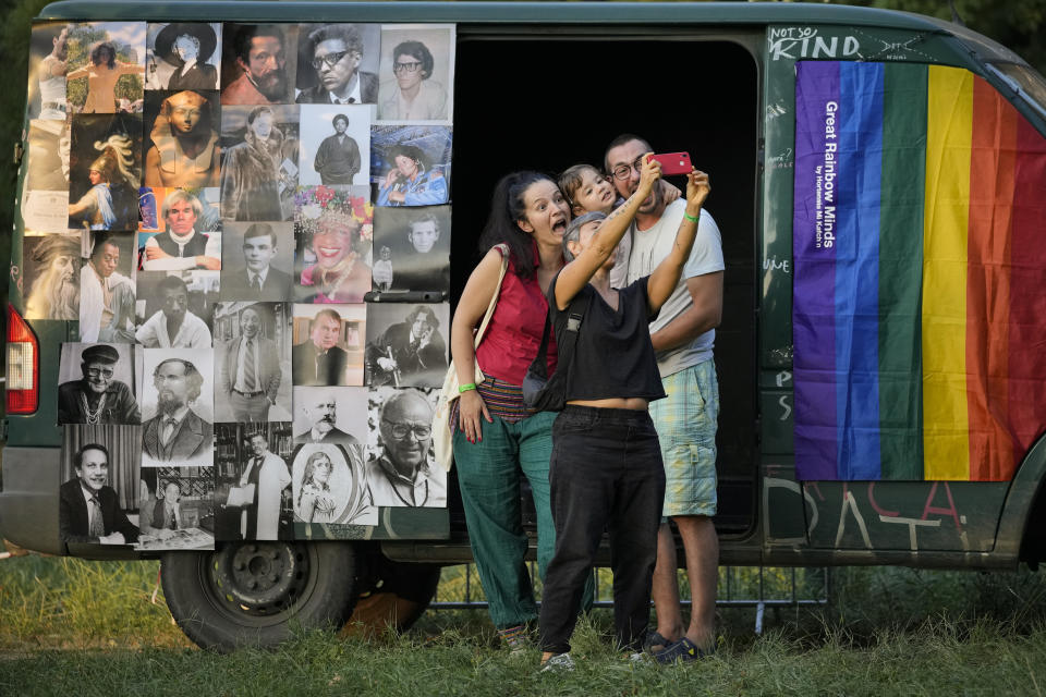 People strike a pose at Pride Park, a venue for artistic shows ahead the Pride 2021 in Bucharest, Romania, Friday, Aug. 13, 2021. The 20th anniversary of the abolishment of Article 200, which authorized prison sentences of up to five years for same-sex relations, was one cause for celebration during the gay pride parade and festival held in Romania's capital this month. People danced, waved rainbow flags and watched performances at Bucharest Pride 2021, an event that would have been unimaginable a generation earlier. (AP Photo/Vadim Ghirda)