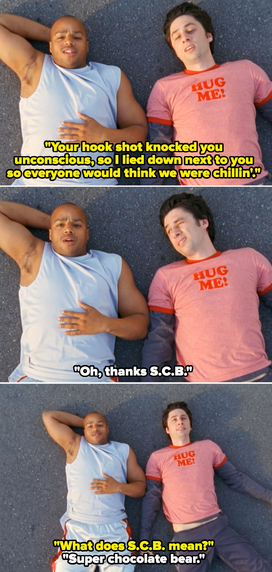 Donald Faison and Zach Braff lie on the ground in casual clothes, with Zach wearing a "Hug Me!" T-shirt