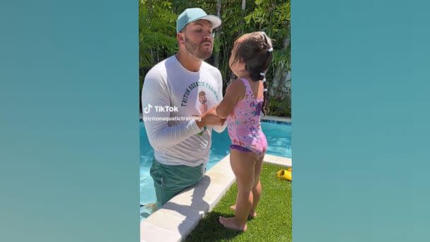 PHOTO: Tyler Reed, the owner of Triton Aquatic Training in Tampa, says a 'mermaid mantra' with a 2-year-old girl. (Triton Aquatic Training)