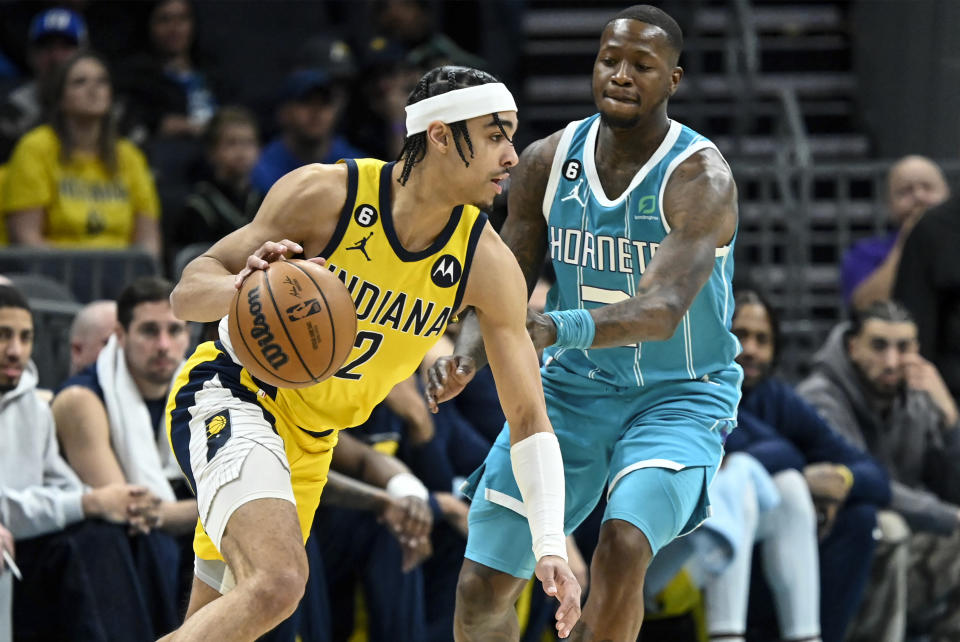 Indiana Pacers guard Andrew Nembhard (2) drives past Charlotte Hornets guard Terry Rozier, right, during the first half of an NBA basketball game, Monday, March 20, 2023, in Charlotte, N.C. (AP Photo/Matt Kelley)