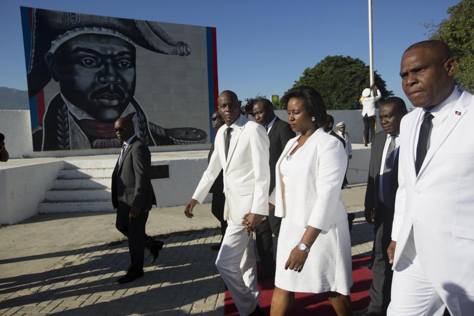 El presidente de Haití, Jovenel Moise, en el centro, y la primera dama, Martine Moise, caminan con el primer ministro Jean Henry Ceant mientras salen de la ceremonia de conmemoración del aniversario del asesinato del héroe de la independencia en Puerto Príncipe, el miércoles 17 de octubre de 2018. (AP Foto / Dieu Nalio Chery)