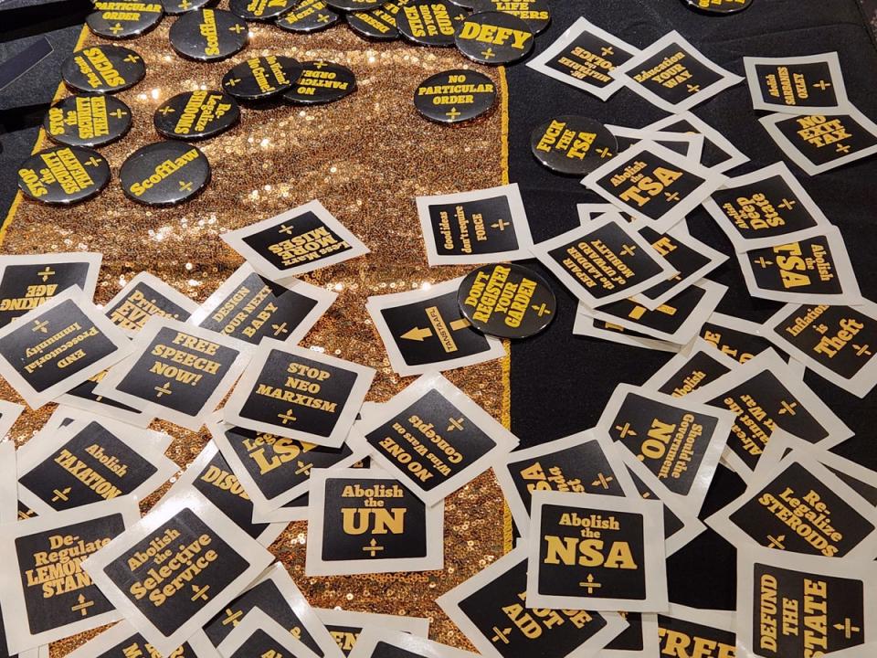 Buttons and stickers with federal-skeptic slogans are handed out at the 2024 Libertarian Party convention in Washington DC (John Bowden)