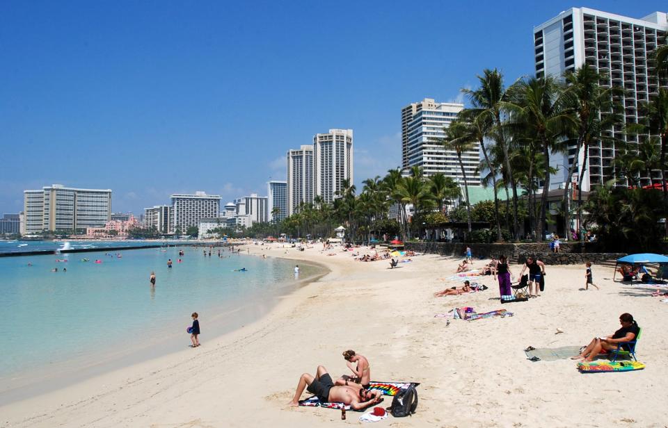 In this Monday, March 13, 2017 photo, people relax on the beach in Waikiki in Honolulu.