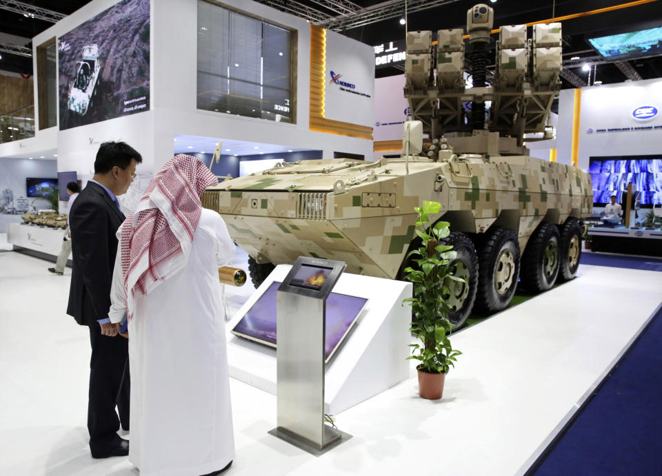 A Chinese salesman speaks to a visitor about a mobile missile launcher made by Norinco at the International Defense Exhibition and Conference in Abu Dhabi, United Arab Emirates, Sunday, Feb. 17, 2019. The biennial arms show in Abu Dhabi comes as the United Arab Emirates faces increasing criticism for its role in the yearlong war in Yemen. (AP Photo/Jon Gambrell)