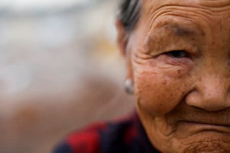 Migrant Mrs Zhong stands near hear home amid demolished neighbourhood houses at the outskirts of Beijing, China October 1, 2017. Picture taken October 1, 2017. REUTERS/Thomas Peter