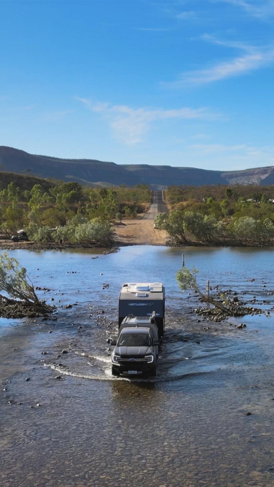 Their caravan driving through some water.