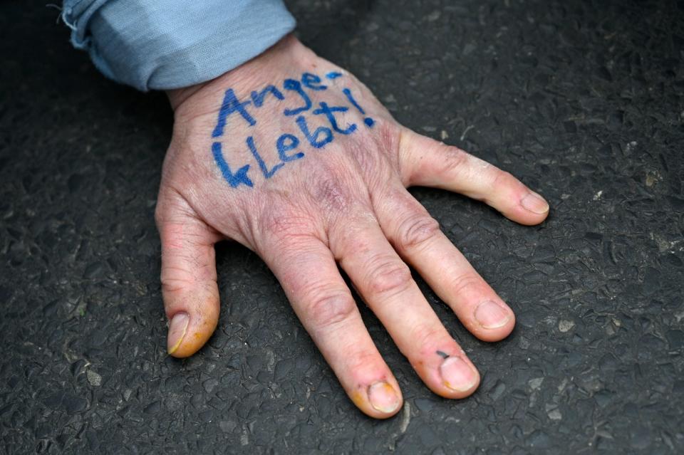 Eine Aktivistin der Extinction Rebellion (XR) hält ihre Hand während einer Protestaktion auf den Boden, während sie eine Straße im Regierungsviertel in Berlin am 6. April 2022 blockiert. - Copyright: getty images