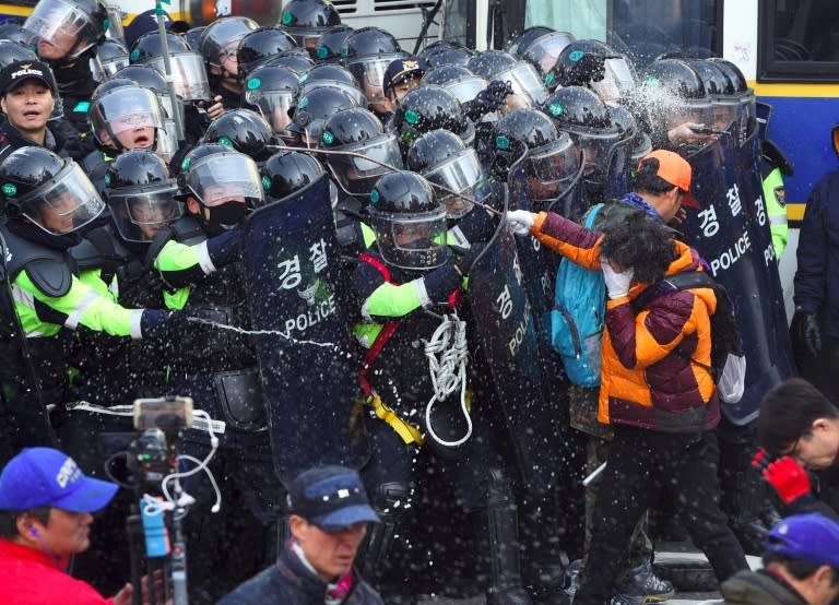 Supporters of South Korean President Park Geun-Hye clash with police in Seoul on March 10, 2017 after the Constitutional Court upheld her impeachment