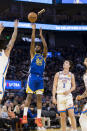 Golden State Warriors forward Andrew Wiggins (22) takes a 3-point shot in front of Oklahoma City Thunder guard Josh Giddey (3) during the first half of an NBA basketball game in San Francisco, Monday, Feb. 6, 2023. (AP Photo/John Hefti)
