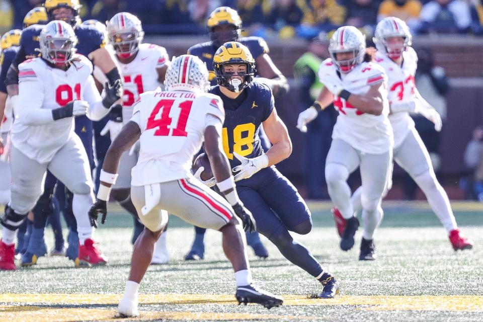 Michigan tight end Colston Loveland runs against Ohio State safety Josh Proctor during the first half at Michigan Stadium in Ann Arbor on Saturday, Nov. 25, 2023.