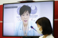 Tokyo Gov. Yuriko Koike, on a screen, speaks as Japanese Olympic Minister Tamayo Marukawa listens during a five-party online meeting at Harumi Island Triton Square Tower Y in Tokyo Monday, June 21, 2021. The Tokyo Olympics will allow some local fans to attend when the games open in just over a month, Tokyo organizing committee officials and the IOC said on Monday. Organizers set a limit of 50% of capacity up to a maximum of 10,000 fans for all Olympic venues. (Rodrigo Reyes Marin/Pool Photo via AP)