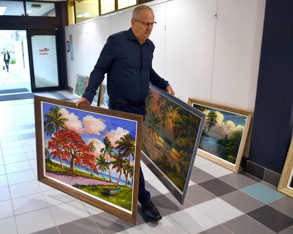Highwaymen art collector Roger Lightle carries paintings by Willie Daniels and James Gibson into Sarasota City Hall Monday morning to begin hanging an exhibit of the Highwaymen's paintings. The exhibit is free and open to the public during City Hall hours, Monday through Friday 8 a.m. to 5 p.m.