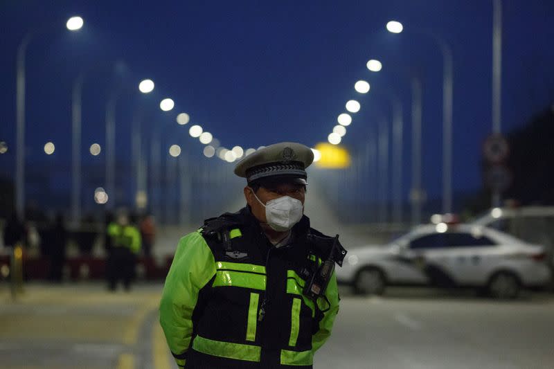 Police officer stands at a roadblock at a bridge crossing the Yangtze River to Hubei province in Jiujiang