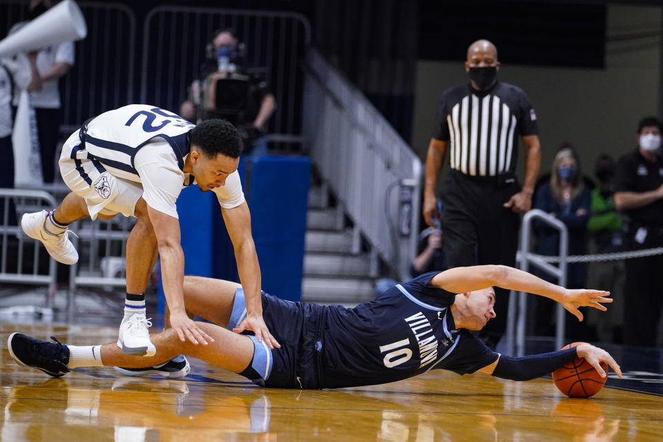 Villanova forward Cole Swider (10) attempts to save the ball under Butler guard Jair Bolden (52) in the second half of an NCAA college basketball game in Indianapolis, Sunday, Feb. 28, 2021. (AP Photo/Michael Conroy)