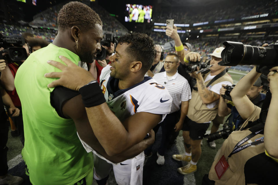 Seattle Seahawks wide receiver DK Metcalf, left, talks with Denver Broncos quarterback Russell Wilson, center, after an NFL football game, Monday, Sept. 12, 2022, in Seattle. The Seahawks won 17-16. (AP Photo/John Froschauer)