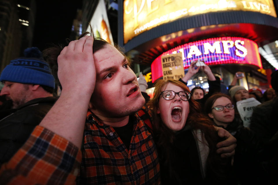Protesters react as police make arrests after protesters rallying against a grand jury's decision not to indict the police officer involved in the death of Eric Garner attempted to block traffic at the intersection of 42nd Street and Seventh Avenue near Times Square, Thursday, Dec. 4, 2014, in New York. (AP Photo/Jason DeCrow)
