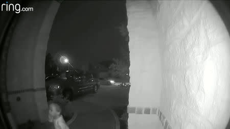 A two-year-old boy is left at a house of a stranger in a northern Houston suburb, as a vehicle flees in the background, in this still image from video released by the Montgomery County Sheriff’s Office in Texas, U.S., on October 18, 2018. Courtesy Montgomery County Sheriff’s Office/Handout via REUTERS