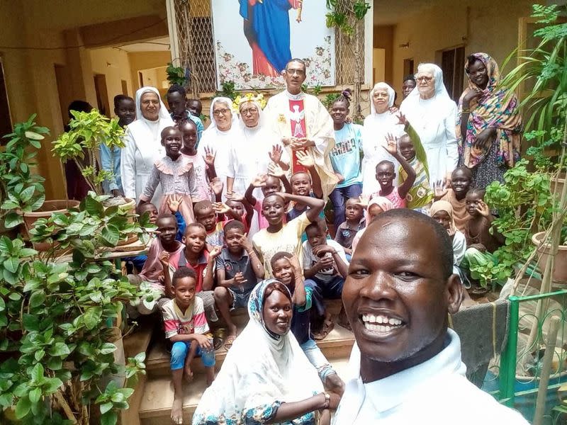 Priest Jacob, nuns and the refugees pose for a photos at "Dar Mariam" a Catholic church and school compound in al-Shajara district, where they took shelter, in Khartoum