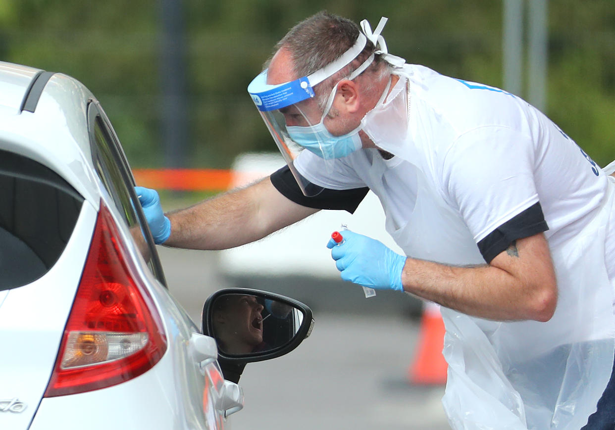 LONDON, UNITED KINGDOM  - MAY 01:  A Medical worker wearing a protective face mask and screen, disposable gloves and a plastic apron, takes a swap at a coronavirus drive-through testing center in the car park of the closed Chessington World of Adventures Resort theme park on May 01, 2020 in London, United Kingdom. British Prime Minister Boris Johnson, who returned to Downing Street this week after recovering from Covid-19, said the country needed to continue its lockdown measures to avoid a second spike in infections. (Photo by Warren Little/Getty Images)