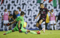 El Salvador goalkeeper Mario Gonzalez (1) blocks a shot by Mexico midfielder Orbelin Pineda (10) during a CONCACAF Group A soccer match, Sunday, July 18, 2021, in Dallas. Mexico won 1-0. (AP Photo/Brandon Wade)