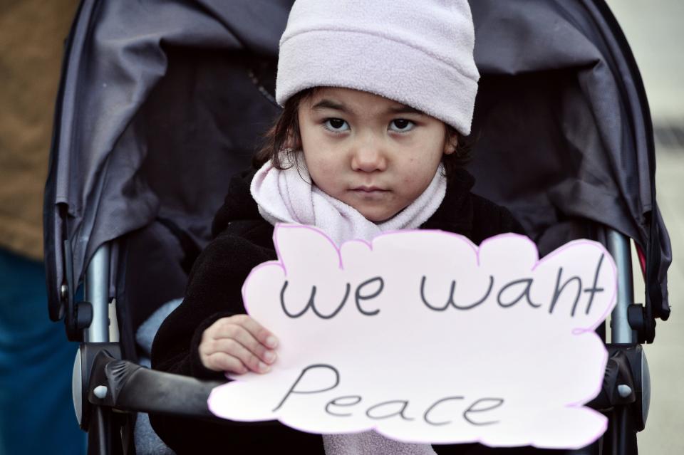 A child carries a sign as migrants and refugees demonstrate in Athens on January 21, 2017, in solidarity with the Women's March on Washington.